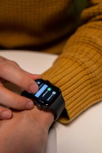 notifica di messaggio su un Apple Watch che indossa un ragazzo con il maglione color senape - Trend low-social life 2026